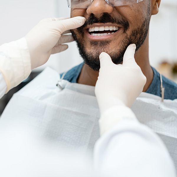 dentist checking handsome guy's teeth