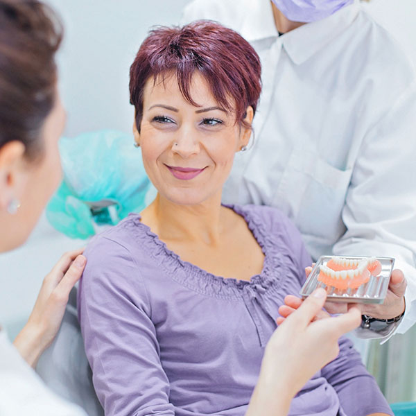 doctor showing patient dentures